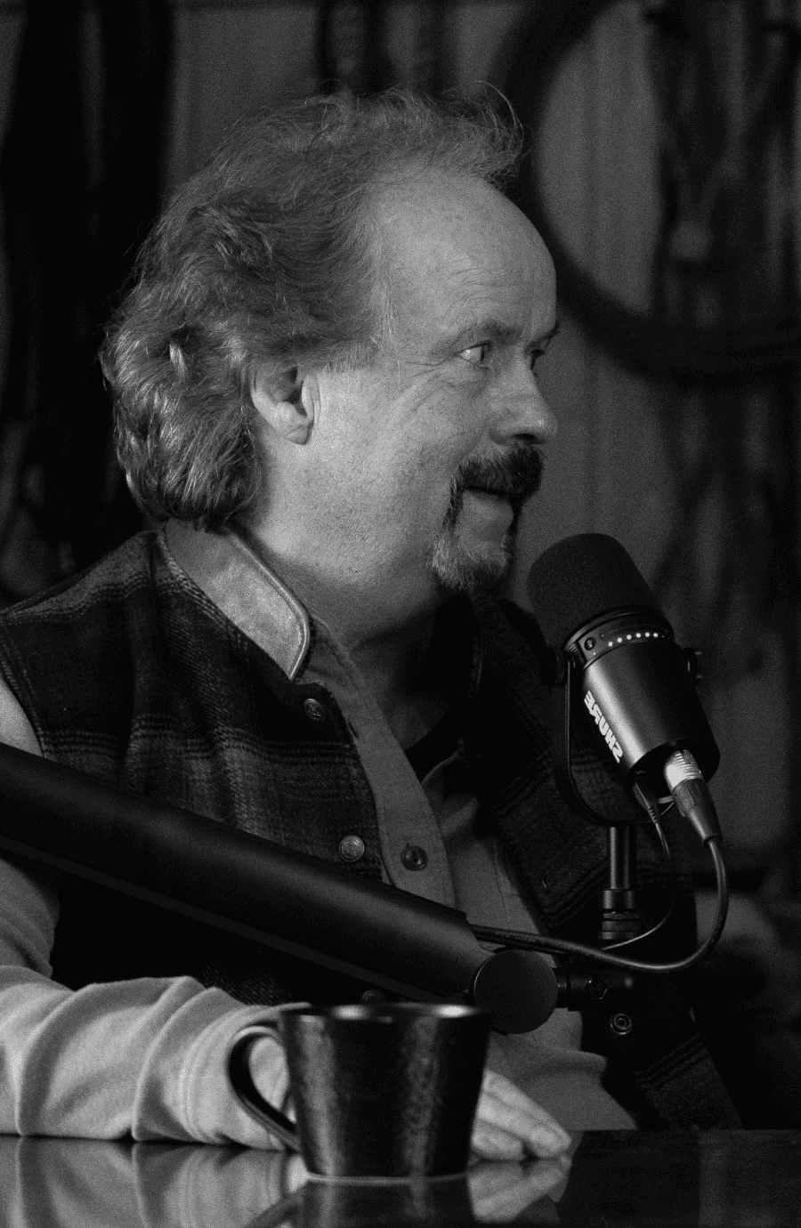 Roy looking to the right while talking during recording of a podcast episode